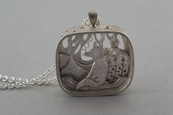 silver fox pendant and diamond star on grey background
