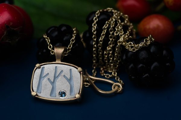 Birch tree necklace on blue bacrground with balckberries and gelder and leaf