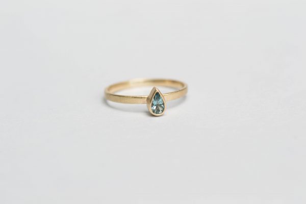 Front view of tear drop ring from afar on gey