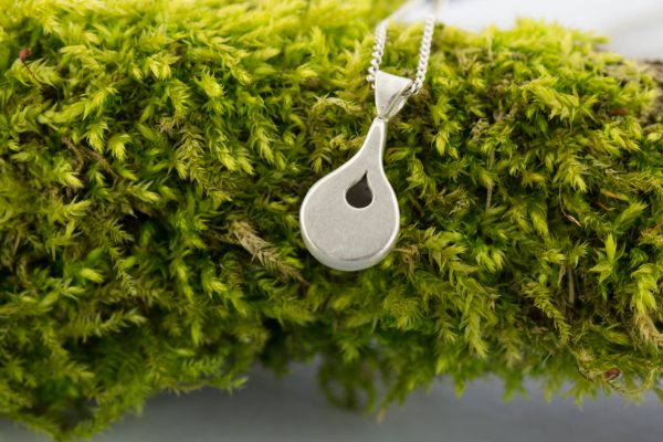 Silver drop locket on moss back view