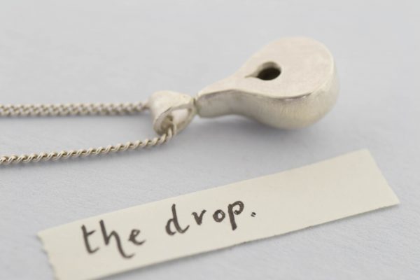 The drop locket back view with note on grey